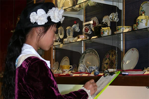 Child in clothes from dress up box doing a scavenger hunt 